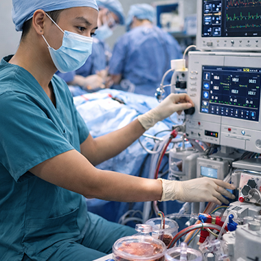 medical professional in scrubs working with monitoring equipment