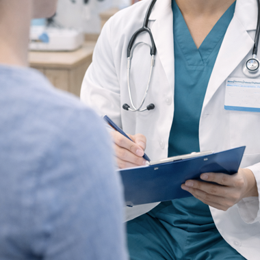 Doctor sitting with a patient going over a chart